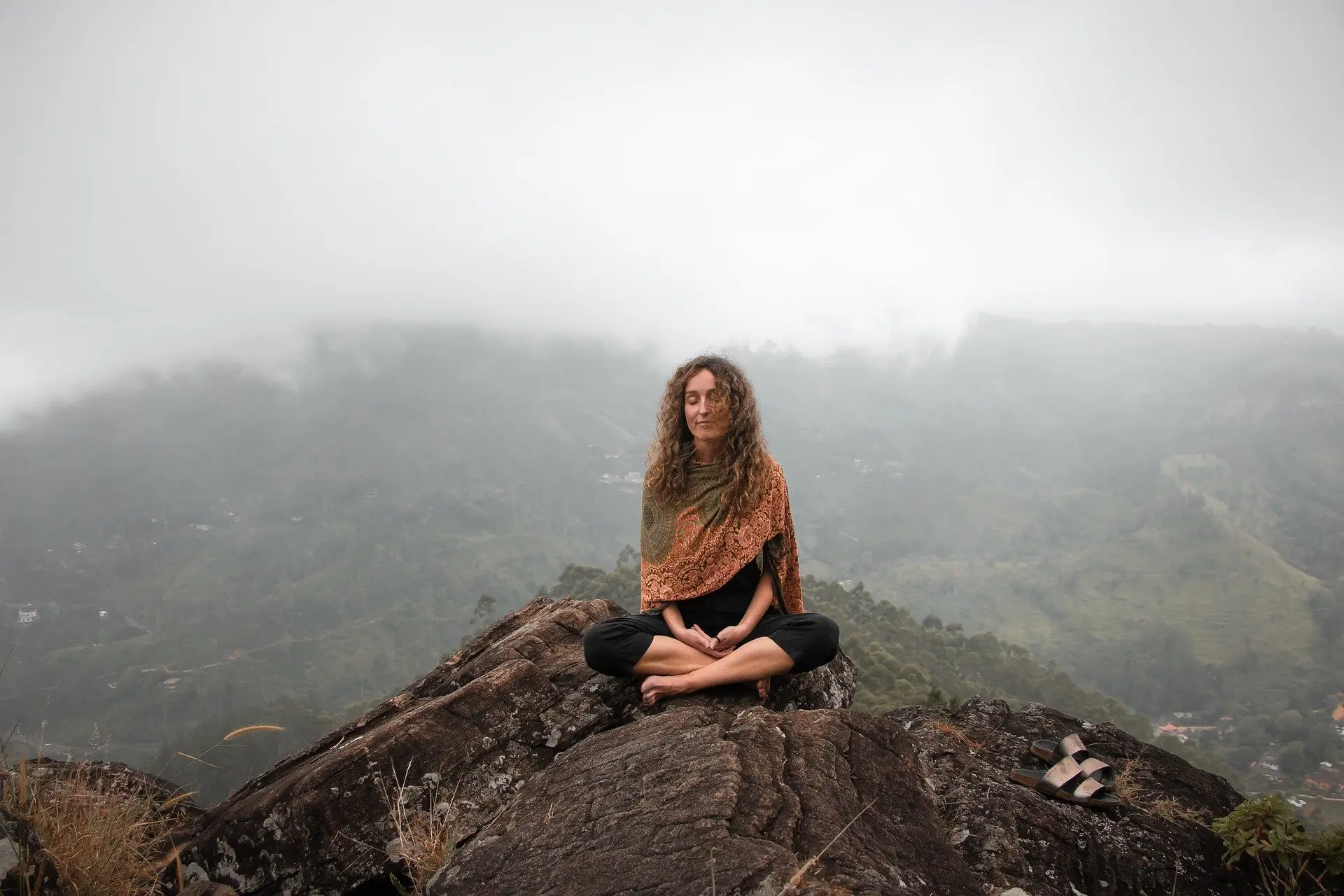 Peaceful woman sitting on a mountaintop woman mountaintop peaceful