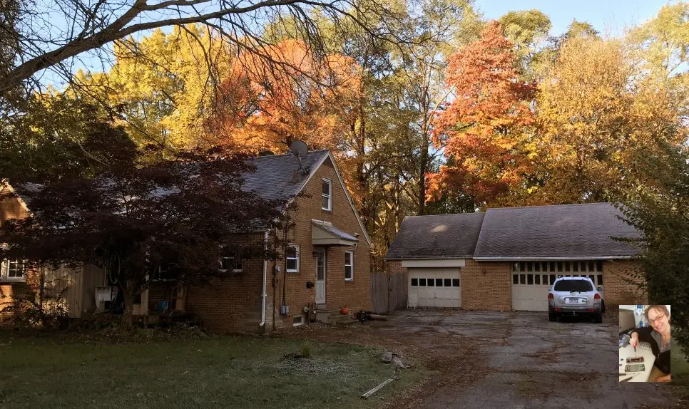 Toledo Ohio location showing a brick home with a three car garage nestled in colorful fall trees